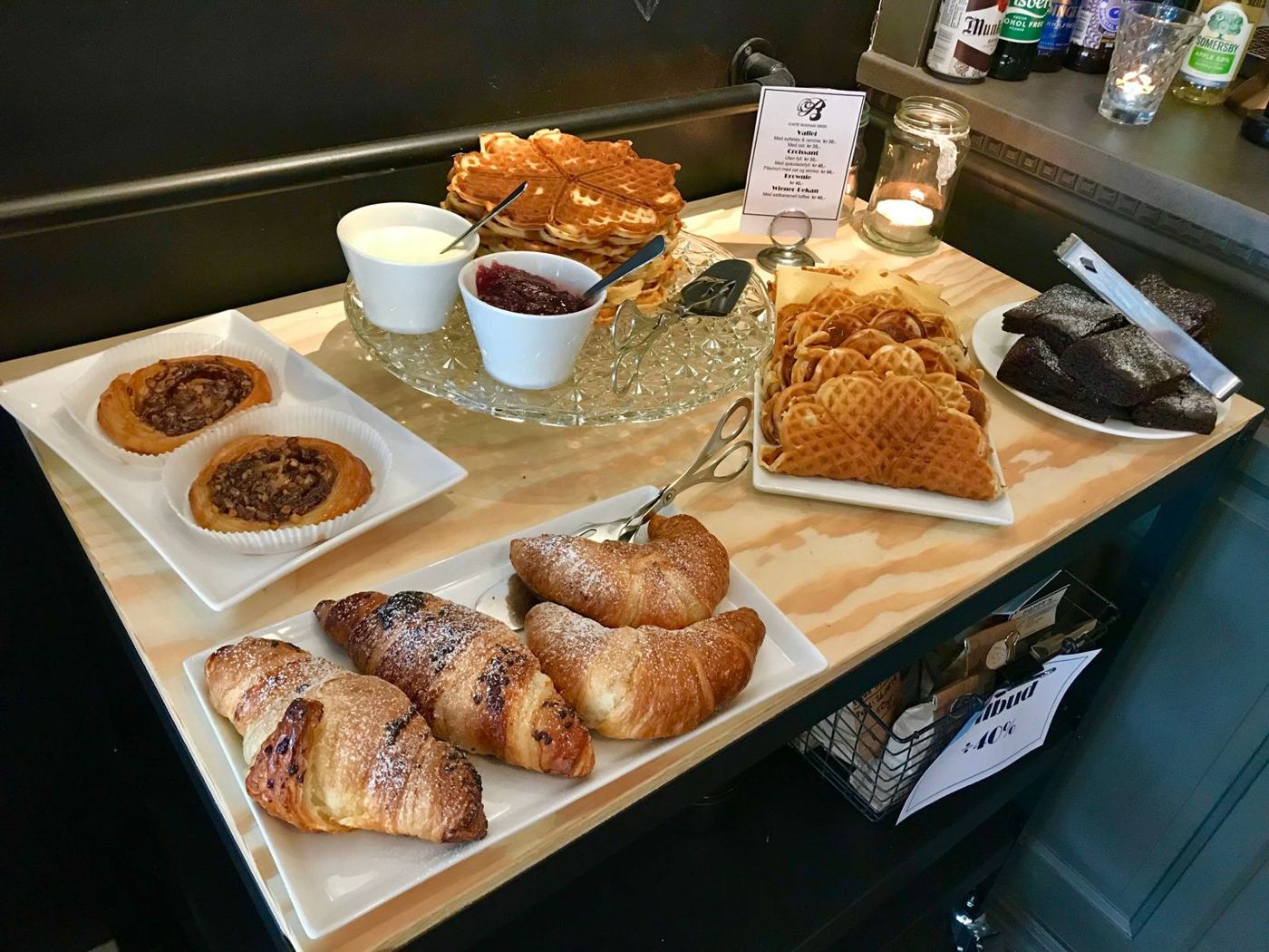 Brett med vafler, croissanter, brownies og bakst på disken